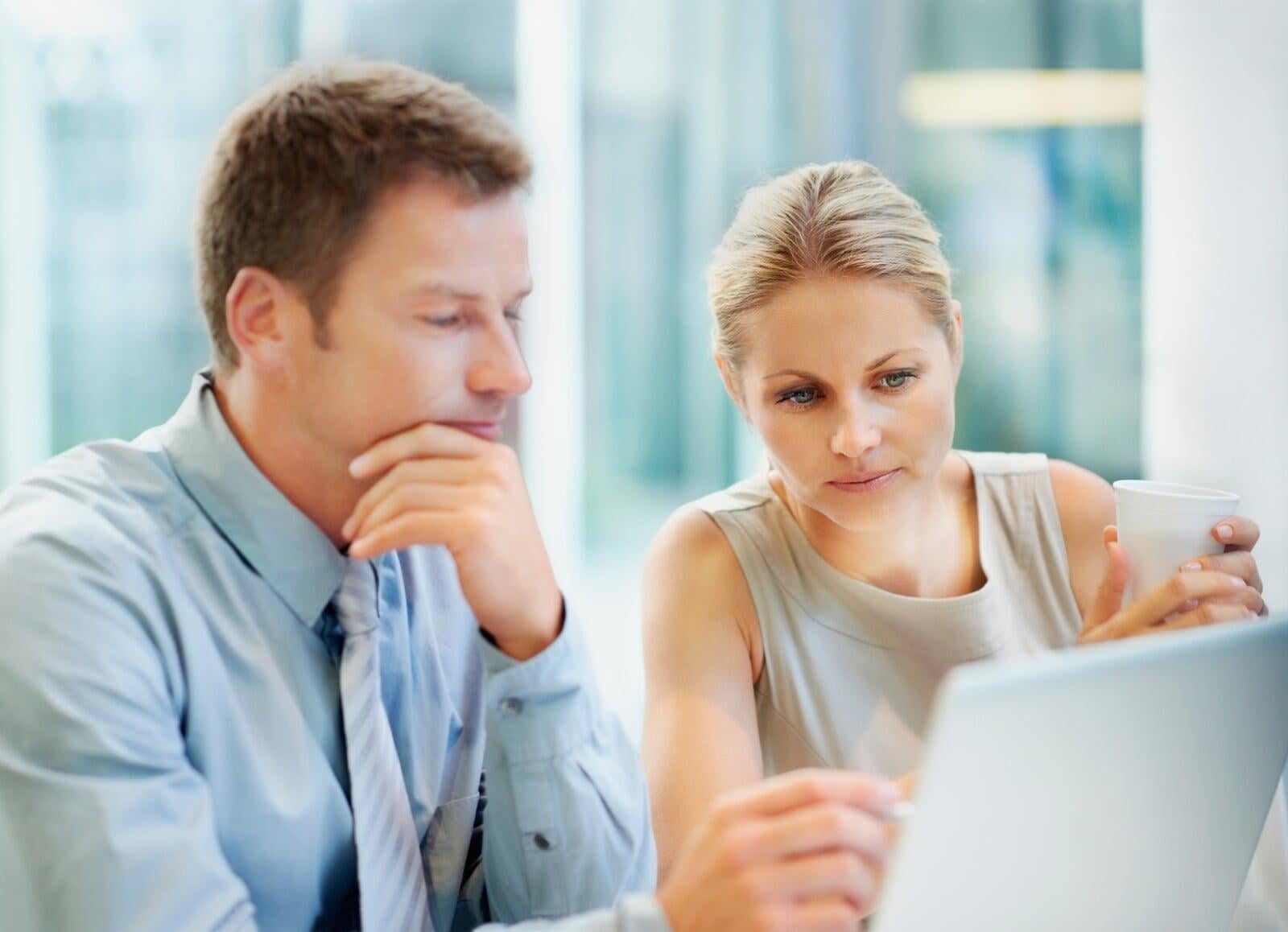 Photograph of a couple looking at their laptop screen.  They are learning about a business from their Limelight Interview.